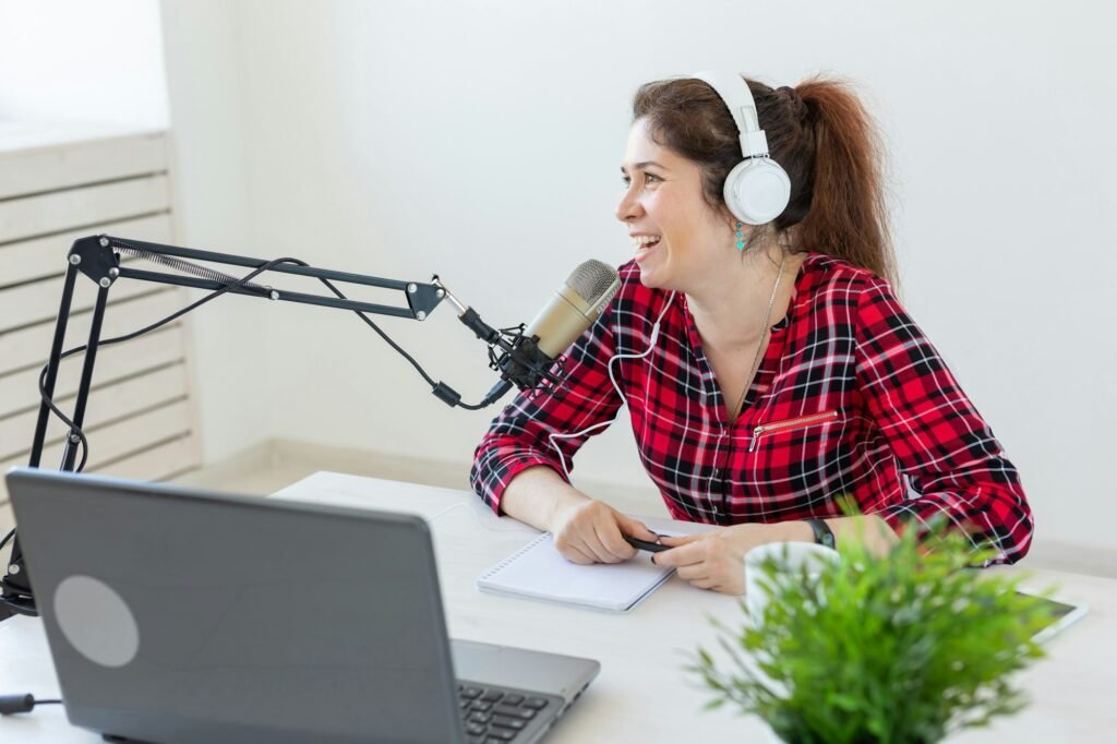 Radio host concept - Joyful woman dressed in plaid shirt working on the radio